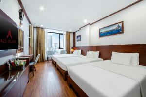 a hotel room with four beds and a desk at A25 Premium Hotel - Bãi Cháy Hạ Long in Ha Long
