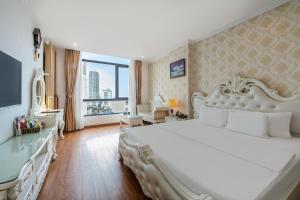 a bedroom with a white bed and a large window at A25 Premium Hotel - Bãi Cháy Hạ Long in Ha Long