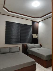 ein Schlafzimmer mit zwei Betten und einem Fenster mit Jalousien in der Unterkunft Bale DT in Angeles + 46 Fotos