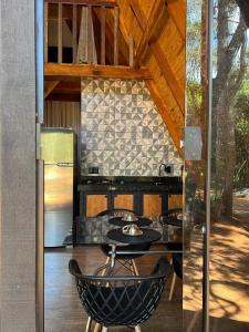 a kitchen with a table and a refrigerator at Cabana Araucária in São Thomé das Letras