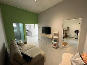 a living room with a couch and a flat screen tv at Mar & Mata 511 in Ubatuba