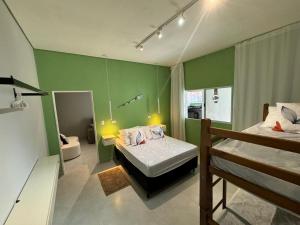 a bedroom with two beds and a green wall at Mar & Mata 511 in Ubatuba