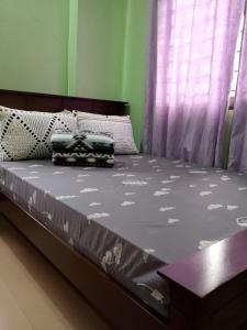 Cama en habitación con cortina púrpura en Balay 257 Camp 7, Baguio City, en Baguio 3 fotos más