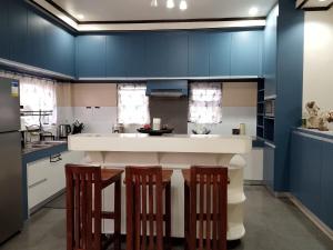 una cocina con paredes azules y una barra con taburetes en Balay 257 Camp 7, Baguio City, en Baguio