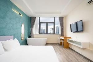 a bedroom with a bed and a tub and a tv at Hoshi Apartment in Ho Chi Minh City