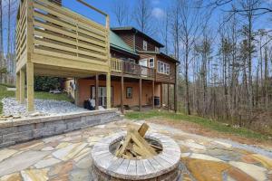 a large house with a deck and a stone patio at The Dream Road Escape Cabin and Hot Tub in Hendersonville