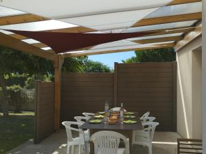 a patio with a table and chairs under awning at Gîte calme proche plage et commerces au Croisic avec jardin, Wi-Fi, 4 chambres - FR-1-306-1308 in Le Croisic