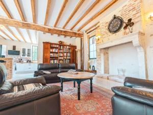a living room with leather furniture and a fireplace at Maison rénovée au cœur du Parc naturel de la Brenne, charme authentique - FR-1-591-734 in Pouligny-Saint-Pierre