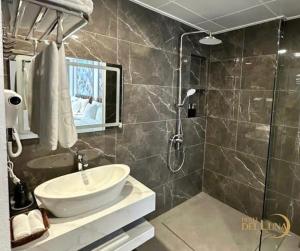 a bathroom with a sink and a shower at Hotel Del Luna in Kon Rung (1)