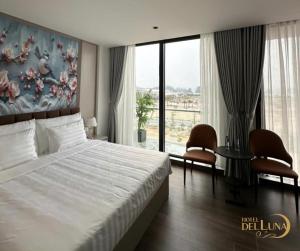 a bedroom with a large bed and a large window at Hotel Del Luna in Kon Rung (1)