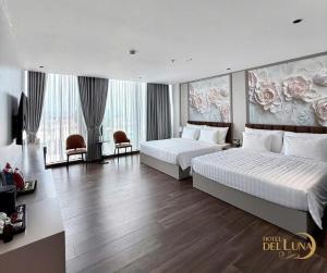 a hotel room with two beds and two chairs at Hotel Del Luna in Kon Rung (1)