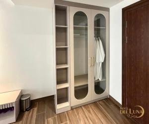 a wardrobe with glass doors in a room at Hotel Del Luna in Kon Rung (1)