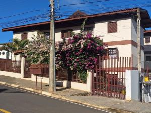 een huis met een hek met bloemen erop bij apartamento águas de lindoia itaigara in Águas de Lindóia