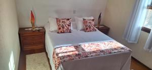 een slaapkamer met een bed met kussens en een raam bij apartamento águas de lindoia itaigara in Águas de Lindóia +29 foto's