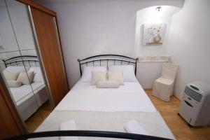 een kleine slaapkamer met een bed en een spiegel bij Apartment Duje in Split