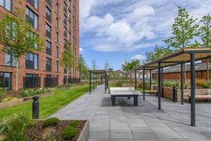 einen Innenhof mit einer Bank und einem Gebäude in der Unterkunft Springwell Suite - City Centre - Balcony & Pool Table - 3 Bed in Leeds