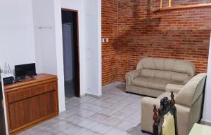 a living room with a couch and a chair at Casa Cabugi Praia JR in Natal
