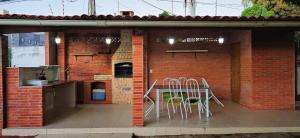 a outdoor kitchen with a table and chairs on a patio at Casa Cabugi Praia JR in Natal