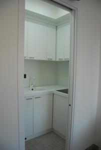 cocina blanca con lavabo y espejo en LHP Suite Rapallo, en Rapallo