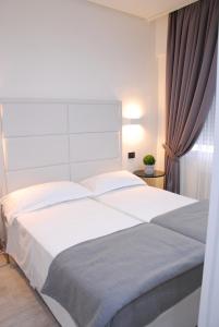 un grande letto bianco in una camera da letto con finestra di LHP Suite Rapallo a Rapallo