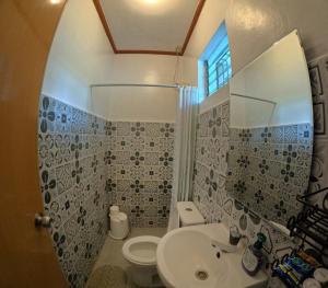 Un baño con lavabo, inodoro y espejo. en The Lighthouse Resort, en Oslob 36 fotos más