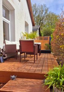 a deck with chairs and a table on a house at Klanggarten - Yoga, Wald, Stadtrand in Lübeck