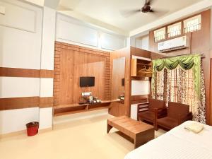a bedroom with a bed and a desk and a television at NE Residency in Guwahati