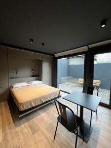 a bedroom with a bed and a table and chairs at Edificio Pantera - monoambiente de diseño in San Martín de los Andes