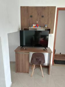 a desk with a television and a chair in a room at Casa Refúgio da Prainha in Arraial do Cabo