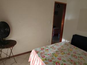 a bedroom with a bed and a chair in a room at Casa Refúgio da Prainha in Arraial do Cabo