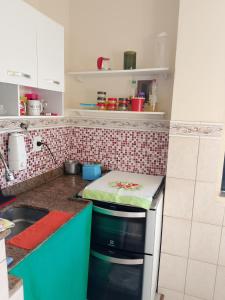 a kitchen with a counter with a stove top oven at Casa Refúgio da Prainha in Arraial do Cabo