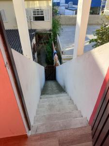a stairway leading up to a house with a person standing on it at Casa Refúgio da Prainha in Arraial do Cabo