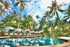 a pool at a resort with palm trees and umbrellas at Lipa Lodge Beach Resort in Lipa Noi