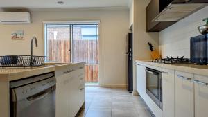 Una cocina con gabinetes blancos y una ventana grande. en Comfy & spacious home near Bellarine Rail Trail, en Curlewis 9 fotos más