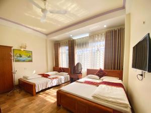 a hotel room with two beds and a television at Công Thành Hotel 1 in Lao Cai
