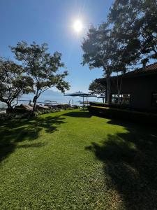a lawn with trees and the sun in the sky at Pecanwood Exclusive Luxury Villa Hartbeesport Dam in Hartbeespoort