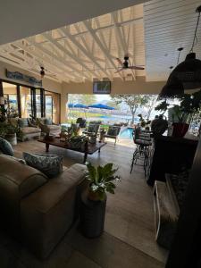 a living room with couches and tables and a pool at Pecanwood Exclusive Luxury Villa Hartbeesport Dam in Hartbeespoort +38 photos