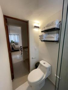 a small bathroom with a toilet and a room at Estancia Madera, A short walk to the Maderas beach in Zihuatanejo
