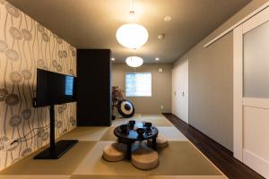 a living room with a table and a tv at おやど紀伊国屋宝町 in Nagasaki