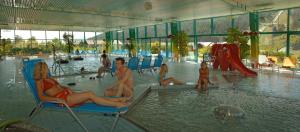 un groupe de personnes assises dans une piscine dans l'établissement Bio-Holzhaus und Landhaus Heimat, à Ramsau am Dachstein