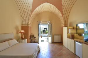 a bedroom with a bed in a room with an arched ceiling at La Zagara in Nardò