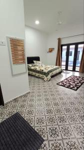 Una habitación con dos camas y suelo de baldosas. en Rina Homestay 2, en Kuala Terengganu