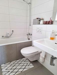 a white bathroom with a toilet and a sink at Fribourg Studio Home in Fribourg