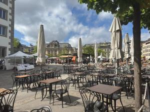 a group of tables and chairs with white umbrellas at Fribourg Home in Fribourg