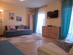 a living room with a couch and a flat screen tv at Apartment Bigovo in Tivat