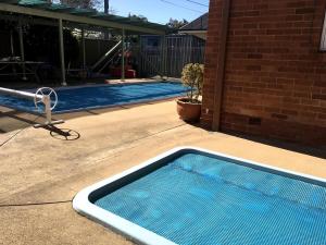 a swimming pool sitting next to a house at Downer Studio - Inner North, Near Chinatown, EPIC in Watson