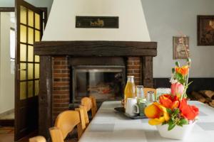 a table with a fireplace with flowers on it at Gite de l'étang in La Puisaye +13 photos
