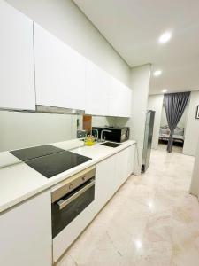 a kitchen with white cabinets and a stove top oven at Modern Condo Next To Petronas Towers in Kuala Lumpur +11 photos