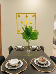 a table with plates and a vase with a plant on it at Modern Condo Next To Petronas Towers in Kuala Lumpur