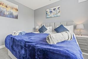 a bedroom with a blue blanket on a bed at Spacious 4-Bedroom Home in Peaceful Coventry Spot in Parkside